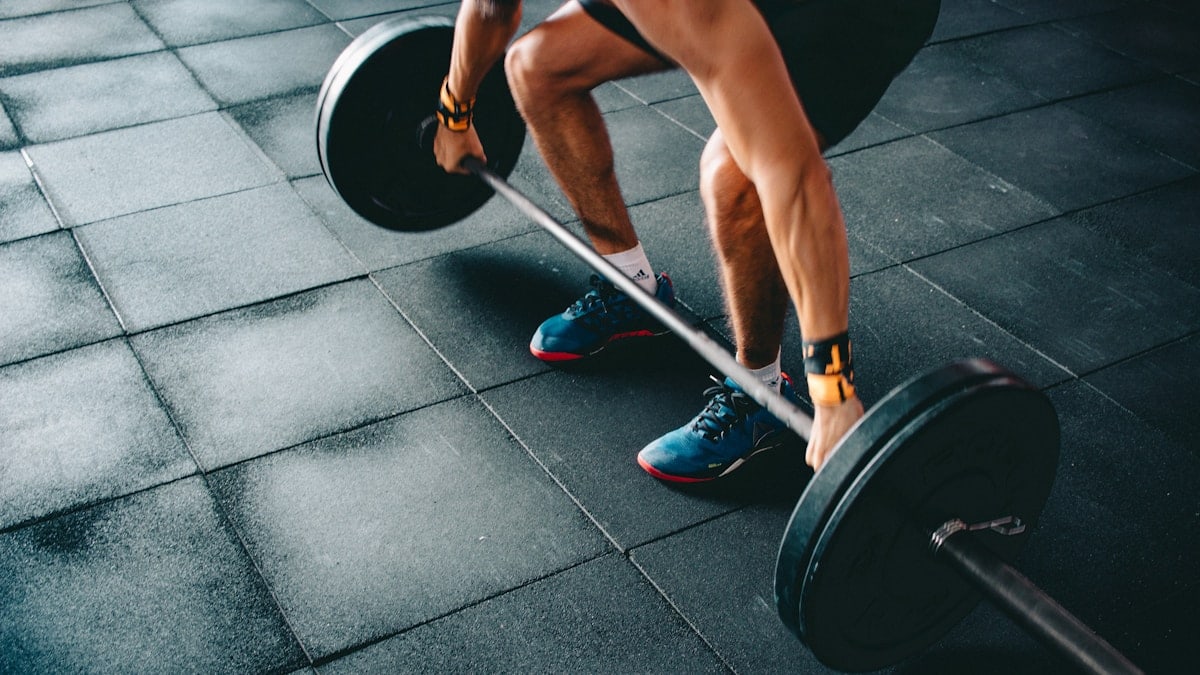 person holding black barbell